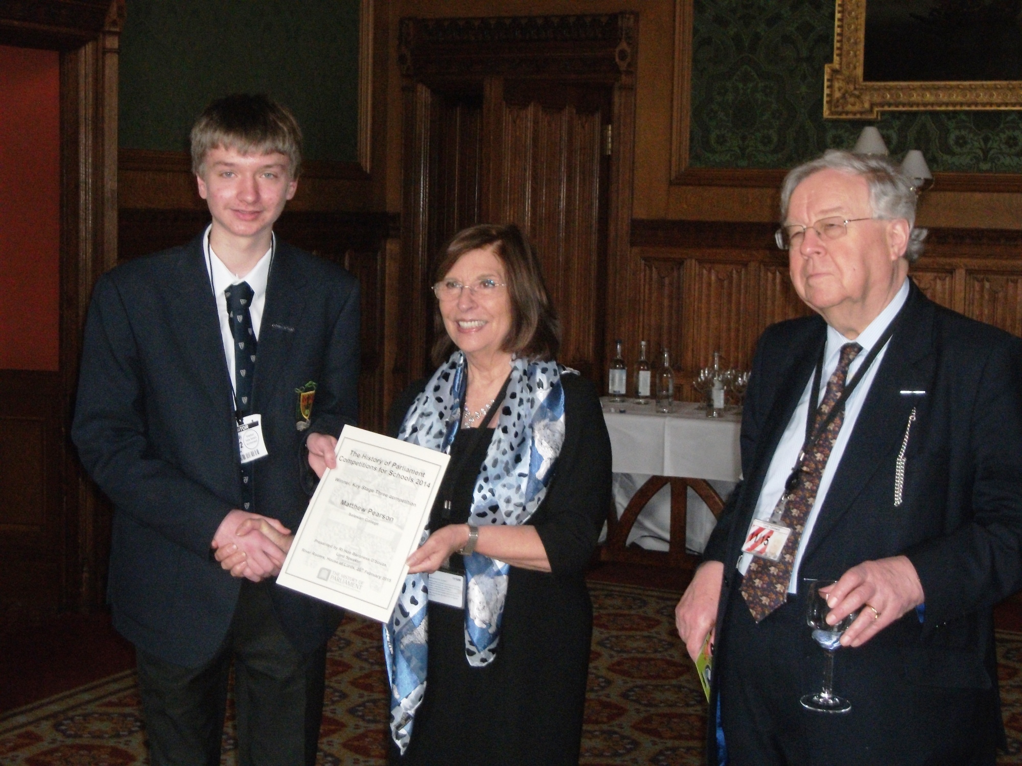 Matthew receiving his prize from Baroness D'Souza, with Lord Cormack
