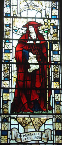A stained glass window depiction of Thomas Bourchier holding a crosier in his left hand and a unrolled scroll in his right hand. He is dressed in red robes and a red hat. He has a white neckline and blue sleeves. The stained glass reads 'Thomas Bourchier 1454-1486'.