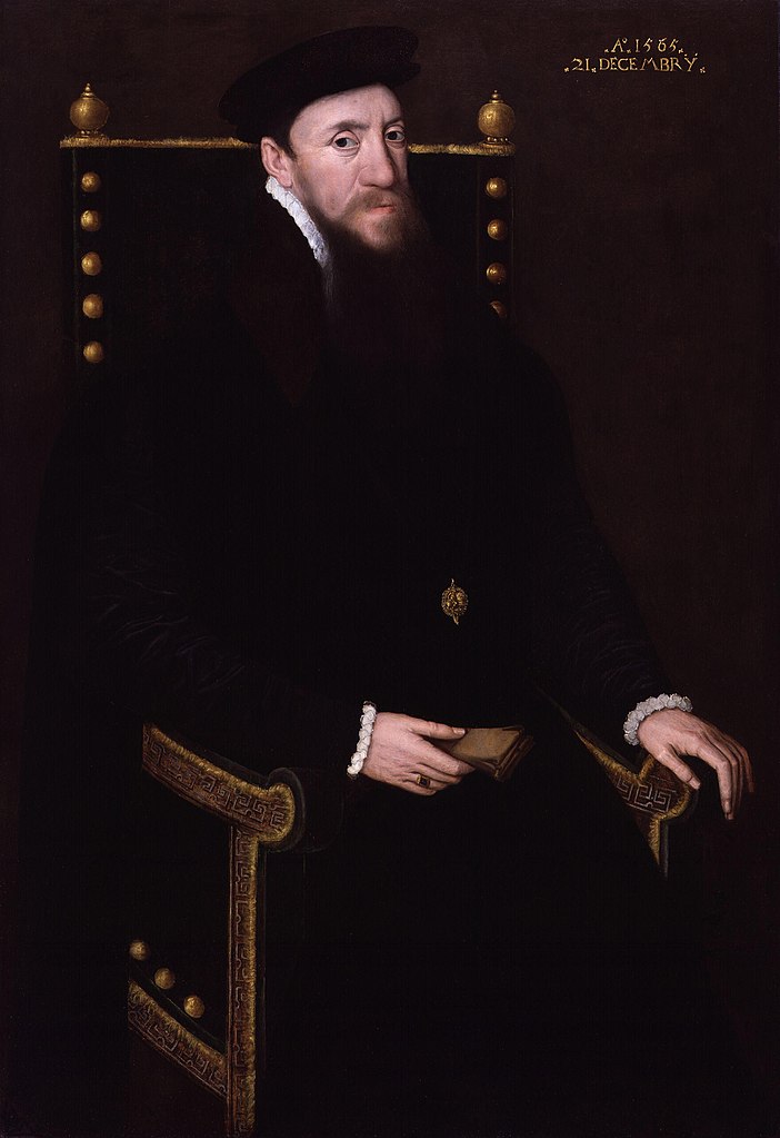 A portrait of a white man sat down in a dark chair decorated in gold. He is wearing black clothing with a white collar and cuffs. His right hand has a ring and is holding something. He is wearing a brooch. The date is written in the top right: A. 1565, 21 December.