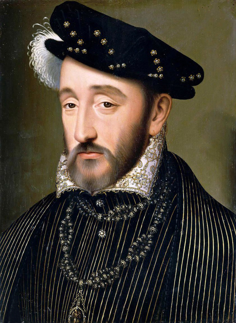 Portrait of King Henri II. He is wearing a black soft hat with a white feather on the side. He has close cropped facial hair. He is wearing a black waistcoat and jacket with gold pin stripes, a large white and gold embroidered collar and black and gold beads on a necklace around his neck.