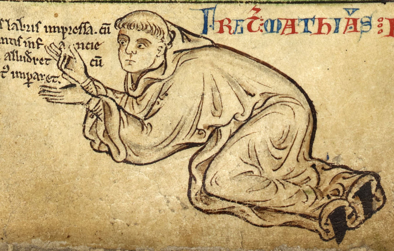 13th century drawing of a monk, Matthew Paris. He is in a kneeling position with his back bent low and his hands pointing upwards. He is wearing robes and has an indication of a bowl-style haircut. Latin writing in the same ink, as well as larger red and blue lettering, surrounds the figure.