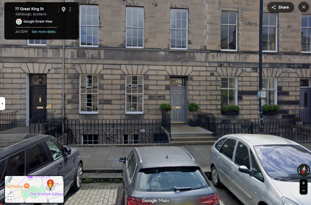 A row of terraced houses with cars outside