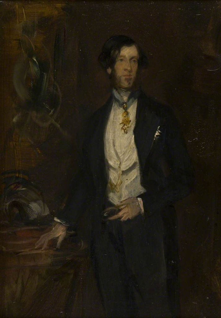 Colour painting of a white man in formal dress. He has dark brown hair and a beard, is wearing a long black coat, black trousers, a white shirt and gold regalia. He is holding a book and has his hand on a globe.