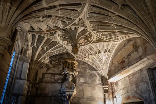 A picture of a fan vault ceiling in the church of St Bartholomew. Next to the vaulted ceiling on the wall is a wall monument to Sir Henry Vernon's son Arthur.