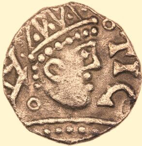 A picture of an Anglo-Saxon silver coin with a portrait picture of a crowned man. 
